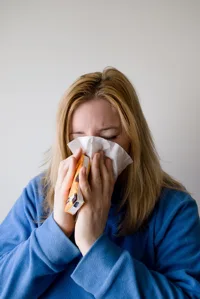 Woman Sneezing Into Tissue Woman Sneezing Into Tissue
