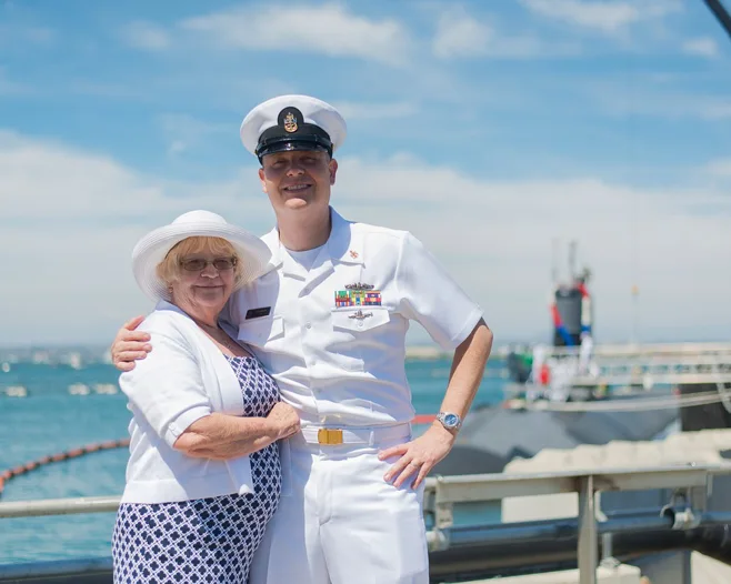 Woman and sailor posing in front of ship Woman and sailor posing in front of ship