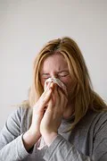 Woman holding tissue to face Woman holding tissue to face