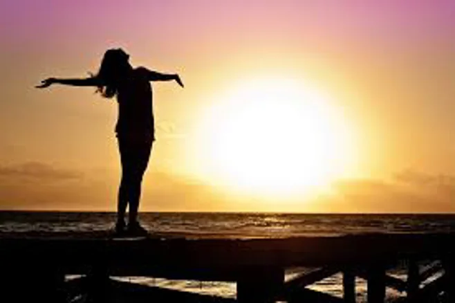 Woman at the beach with arms outstretched Woman at the beach with arms outstretched