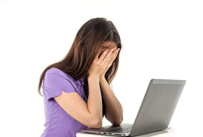 young caregiver frustrated in front of computer young caregiver frustrated in front of computer