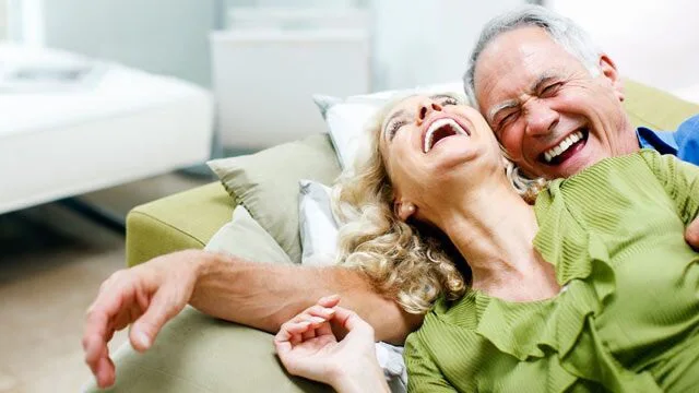 happy couple on sofa laughing happy couple on sofa laughing