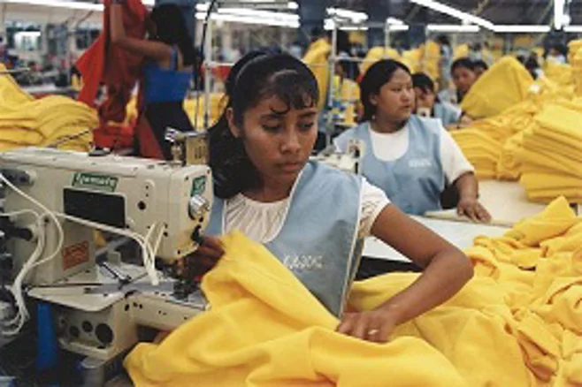Workers in a sweatshop sewing Workers in a sweatshop sewing